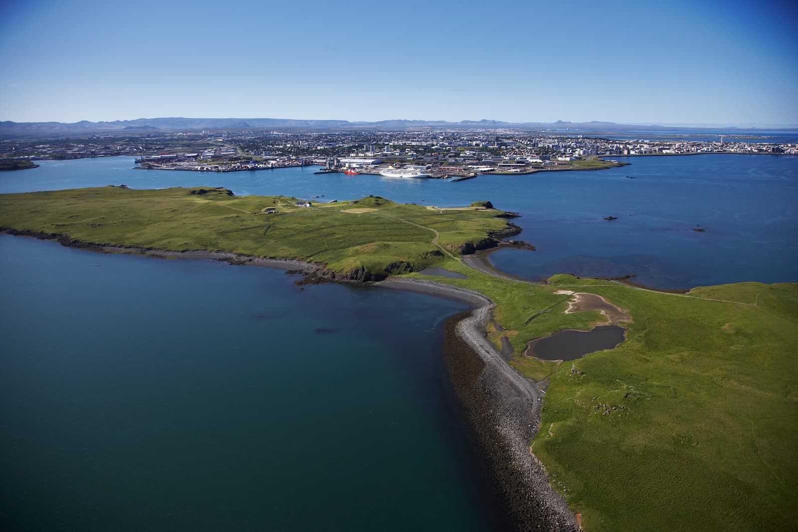 Aerial view of Viðey island in Kollafjörður with Reykjavík across the water