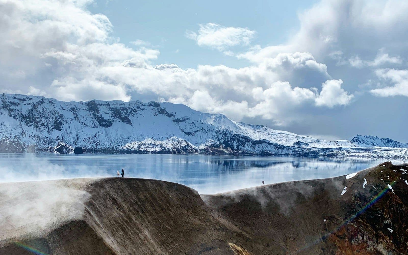 Víti crater lake below snowy Dyngjufjöll mountains and Öskjuvatn inside Askja Caldera.