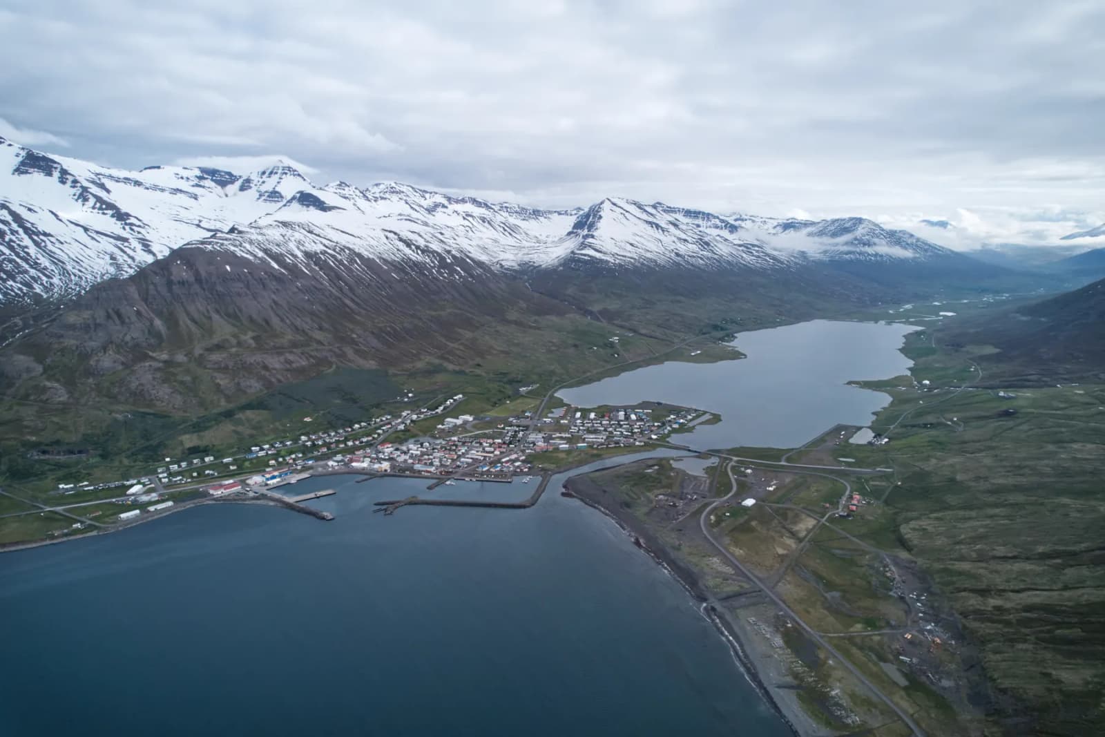 Ólafsfjörður town beside its fjord and lake under steep North Iceland mountains