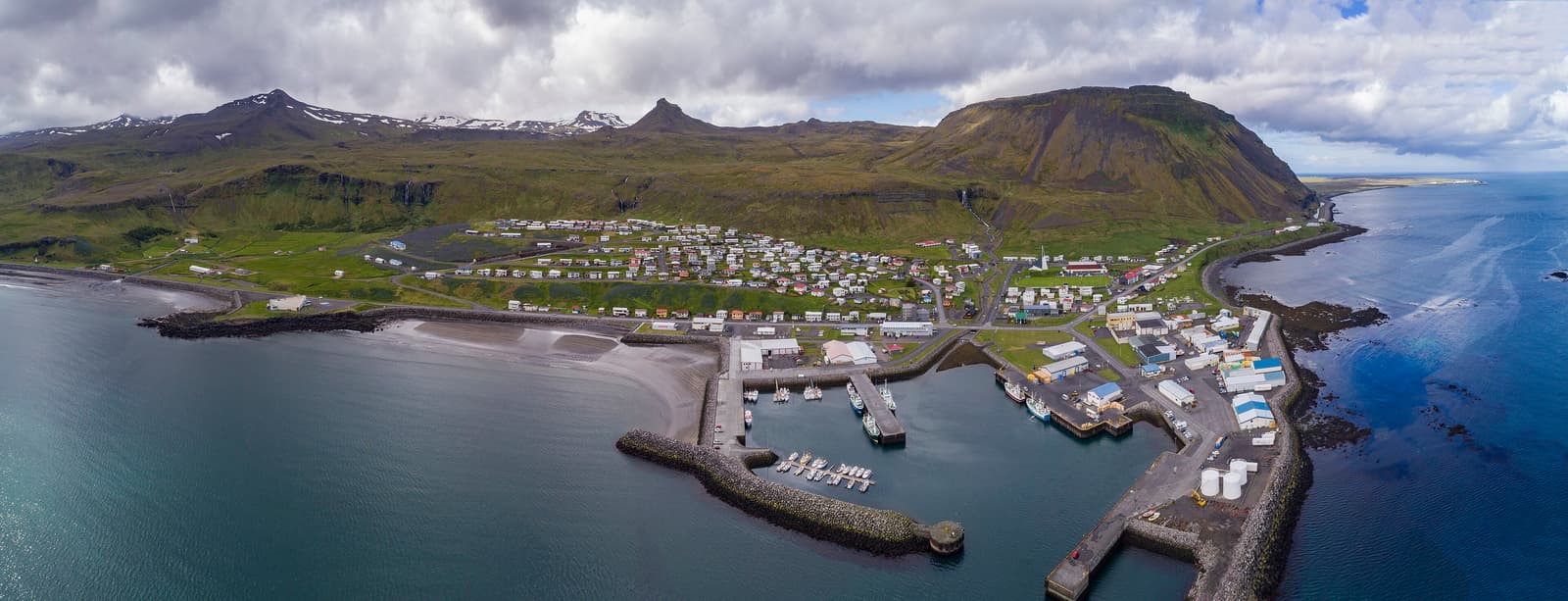 Aerial panorama of Ólafsvík, its harbor, church, coastline, and surrounding mountains