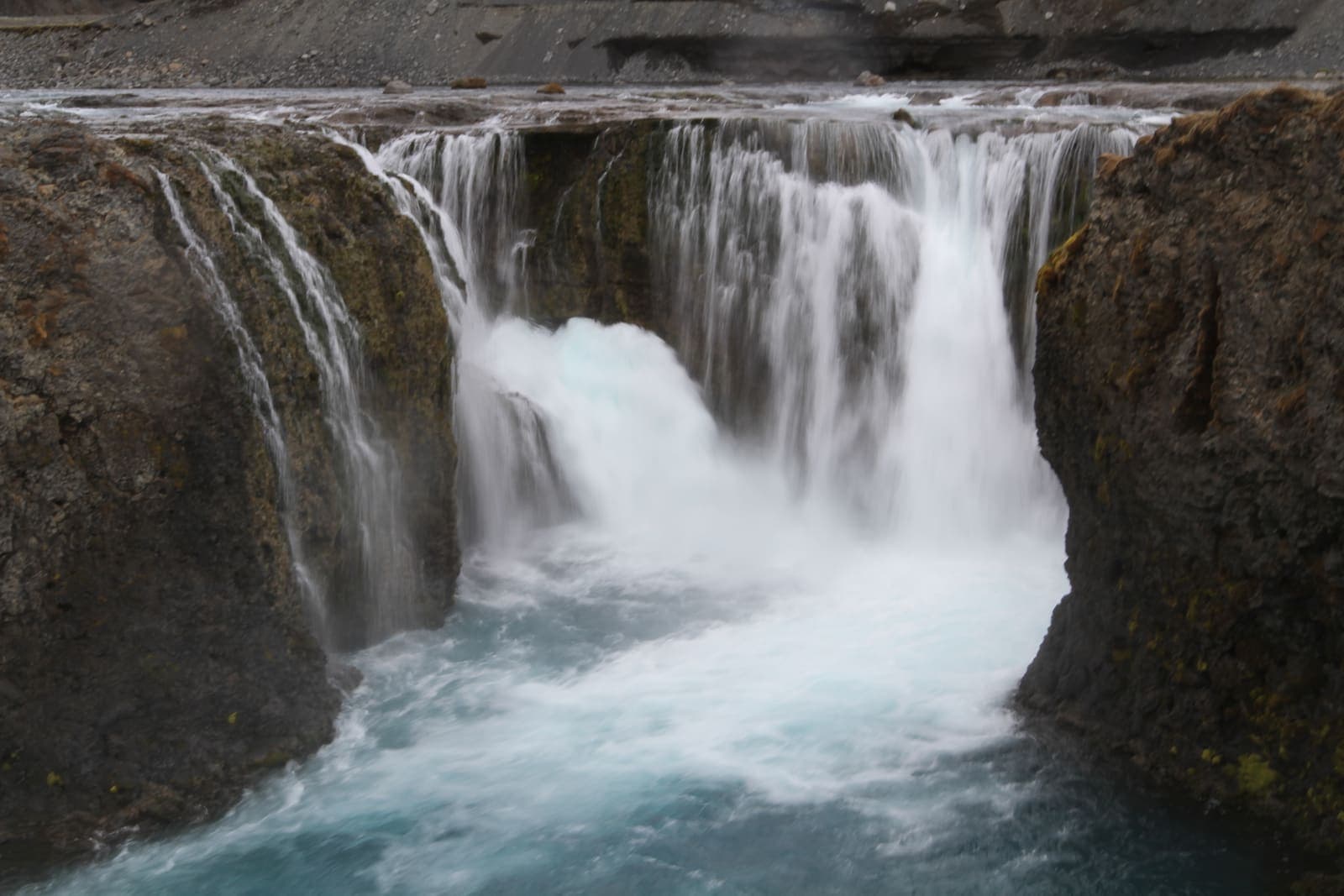 Sigöldufoss dropping over dark rock into pale blue water on the Tungnaá.