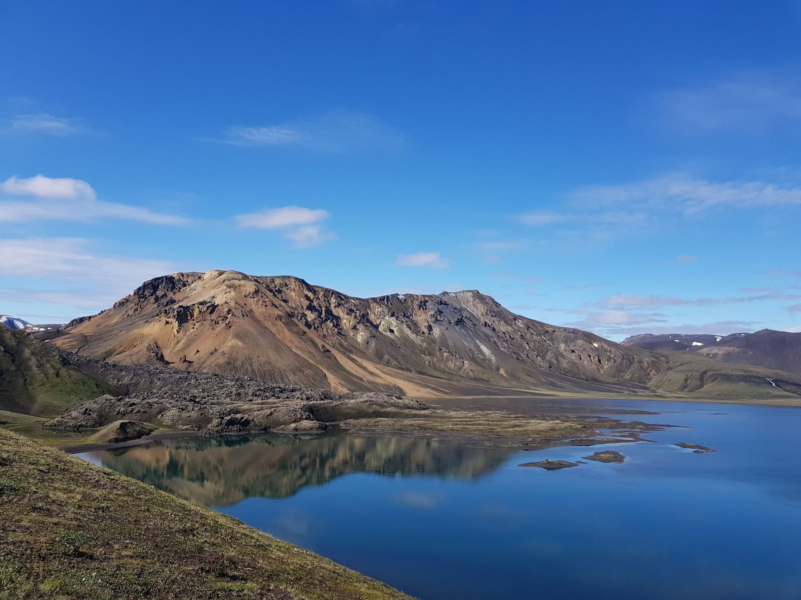 Frostastaðavatn lake reflecting brown and grey mountains in Fjallabak Nature Reserve.