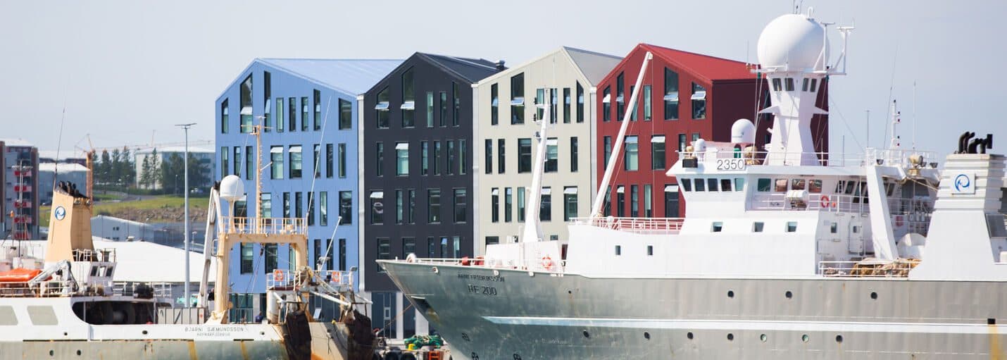 Fishing vessels and colorful harbor buildings in Hafnarfjörður.