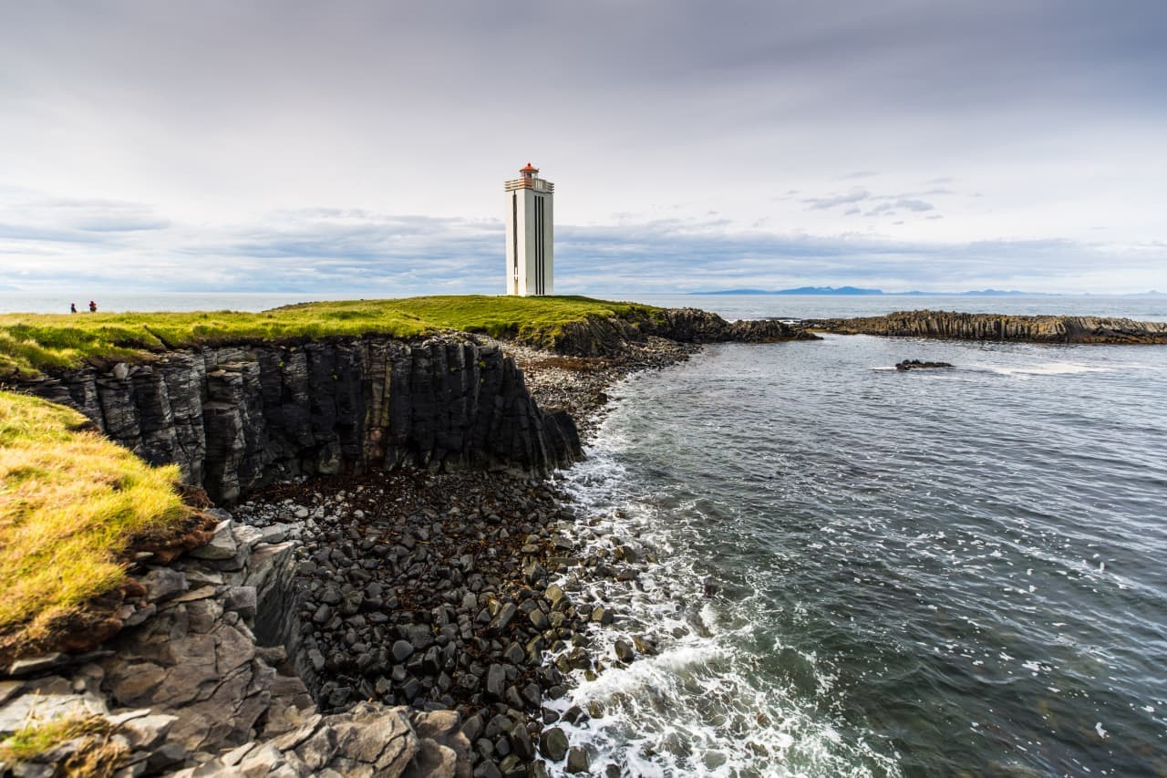 Kálfshamarsvík lighthouse and basalt shore beside Húnaflói bay in North Iceland.
