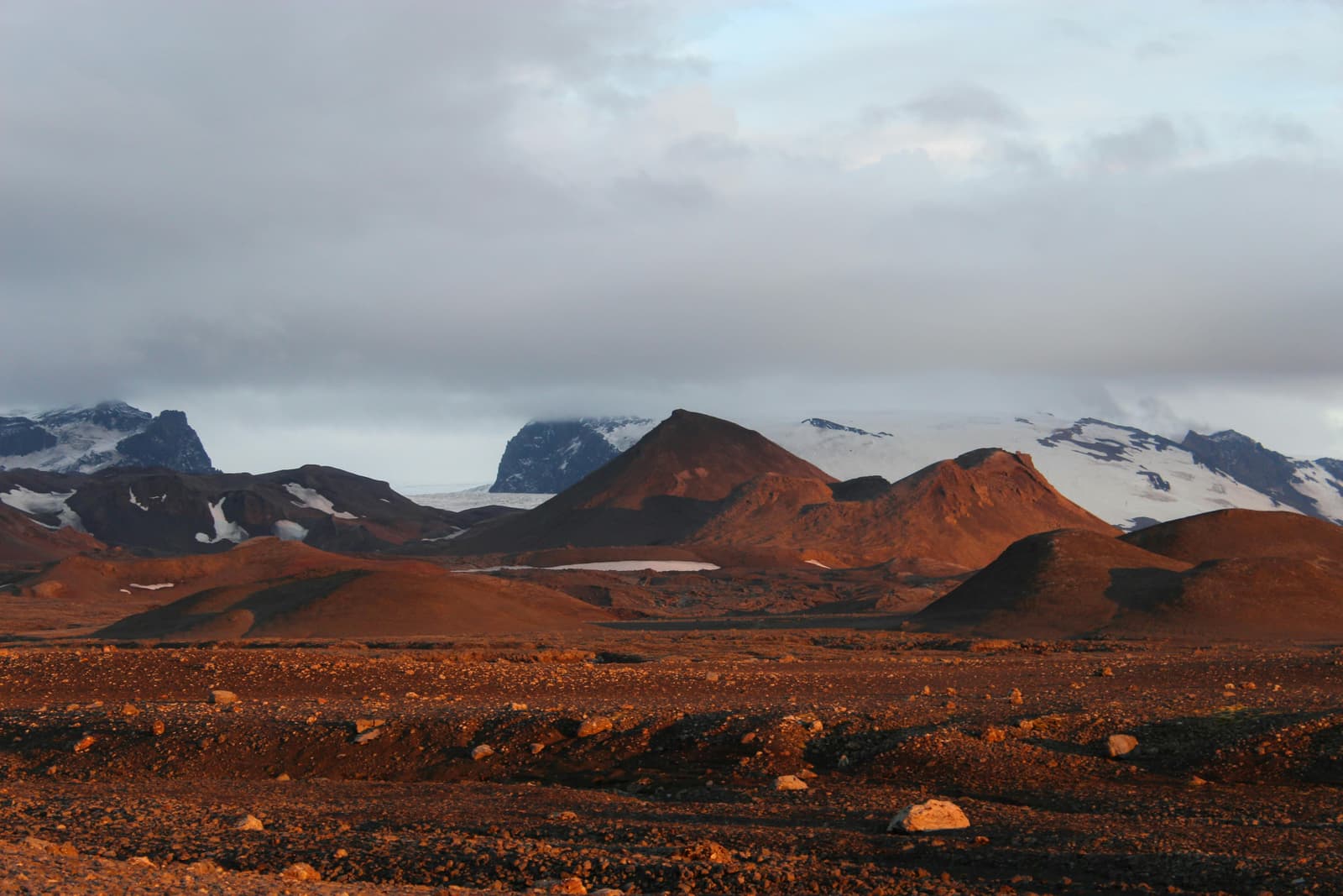 Kverkfjöll volcanic mountains and glacier ice lit by low sun above dark highland terrain.