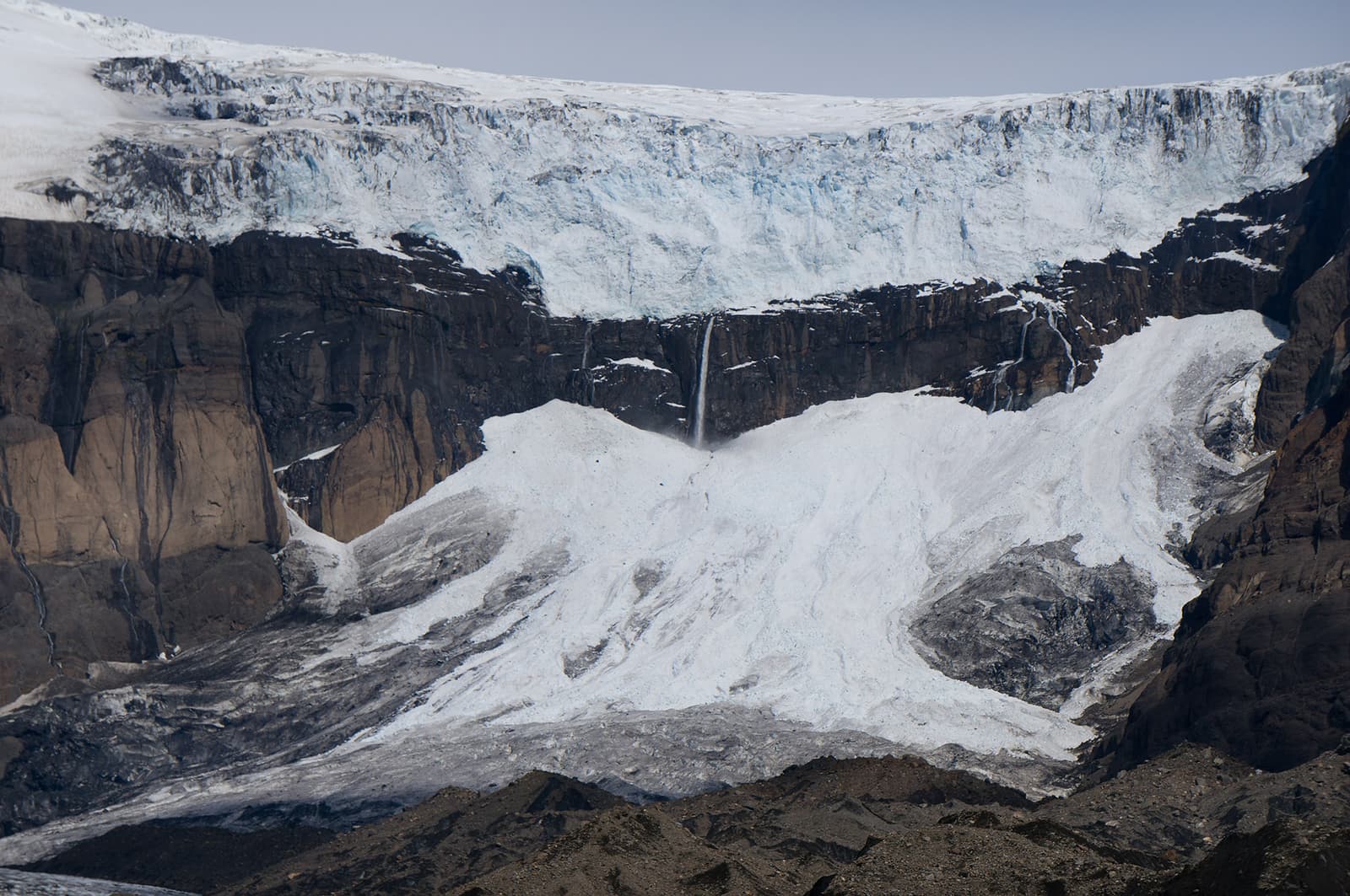 Morsárfoss dropping from a dark cliff below Morsárjökull glacier in Vatnajökull National Park.