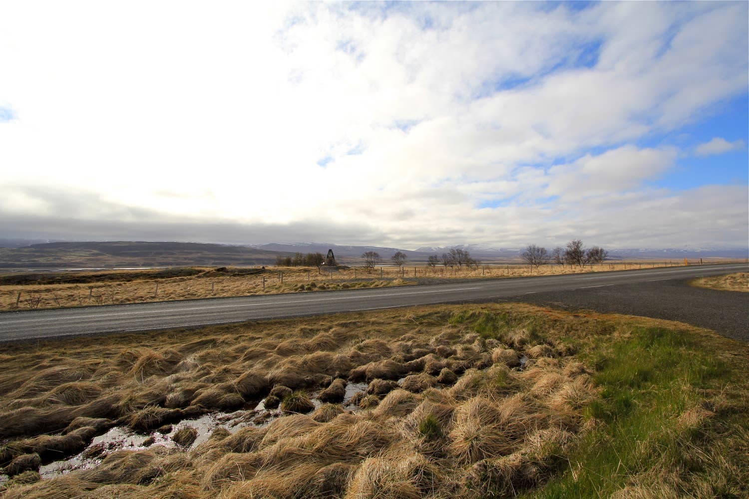 Open fields and low hills around the Örlygsstaðir historical site in Skagafjörður.