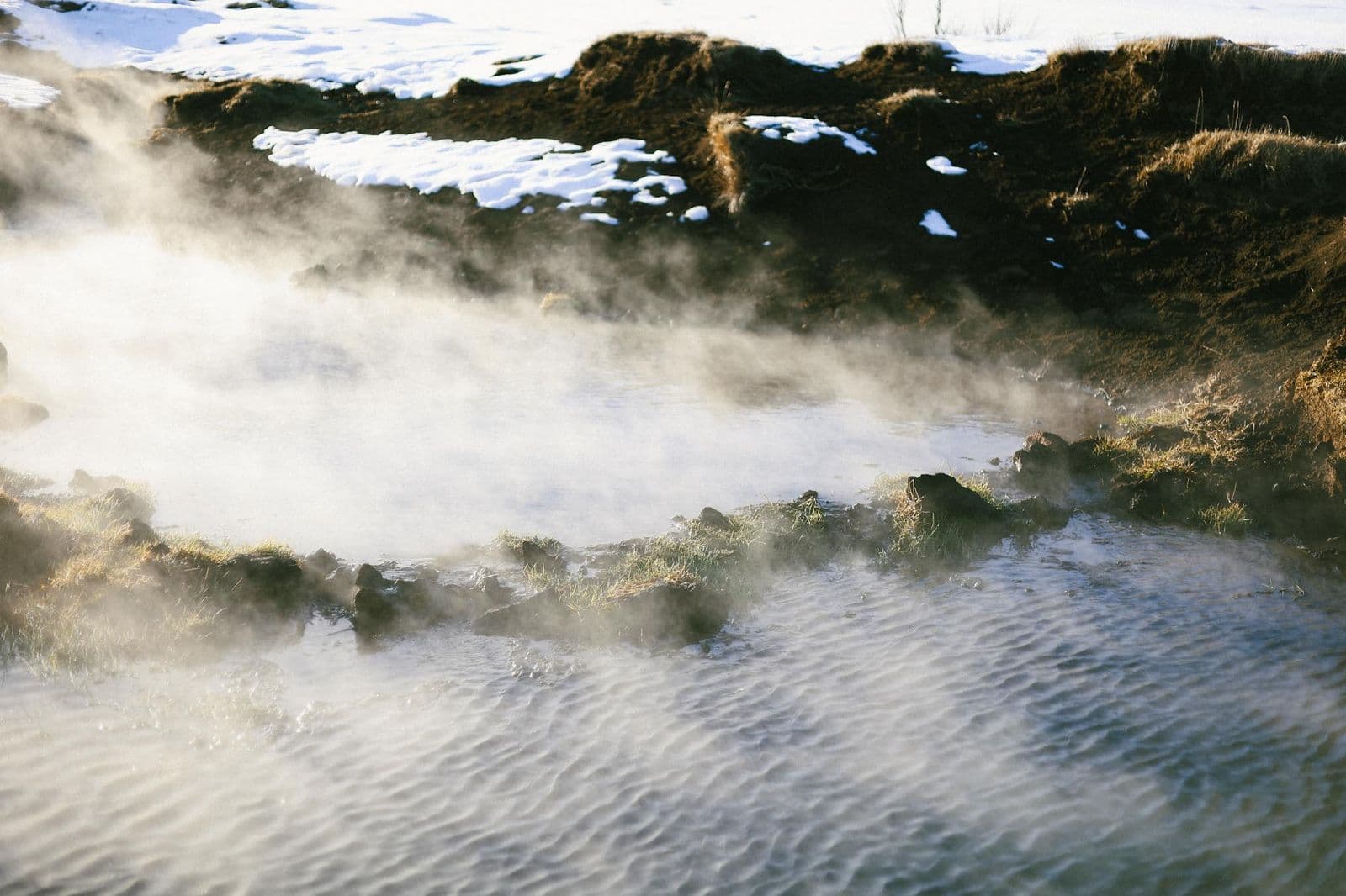 Steam drifting across the natural bathing pool at Skátalaug Hot Spring on the Reykjanes Peninsula.
