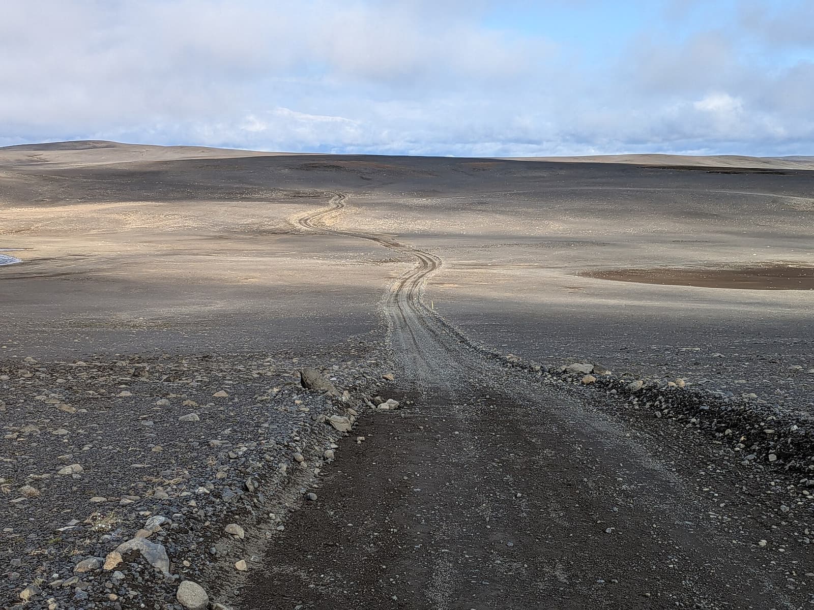 A long gravel track crossing the barren Sprengisandur plateau in Iceland's central Highlands.