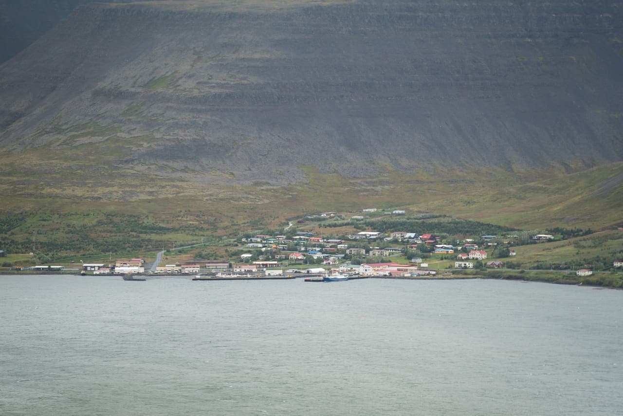 Tálknafjörður village and harbor below steep Westfjords mountains across the fjord.