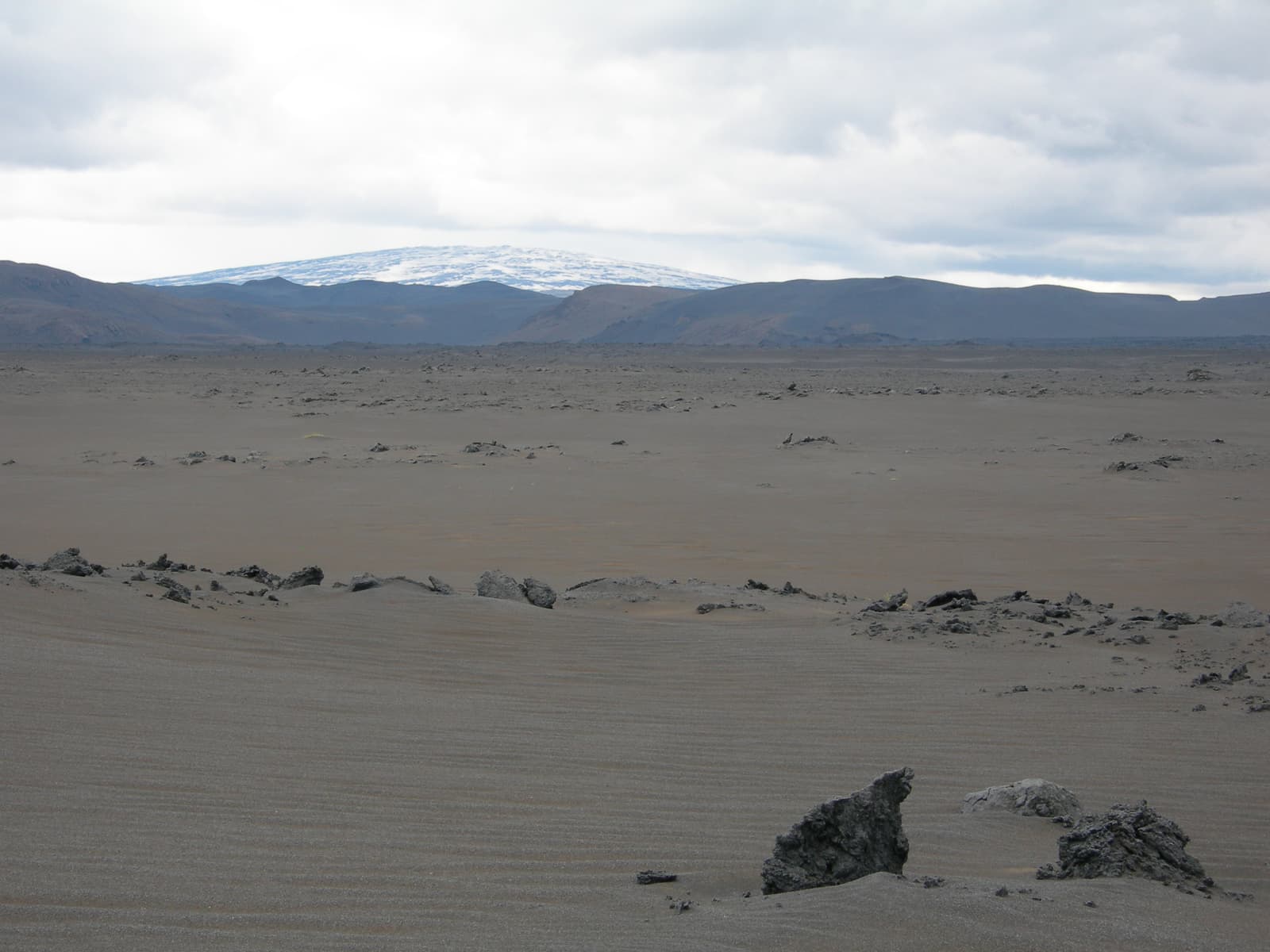 Trölladyngja shield volcano beyond grey lava desert in the north Iceland Highlands.