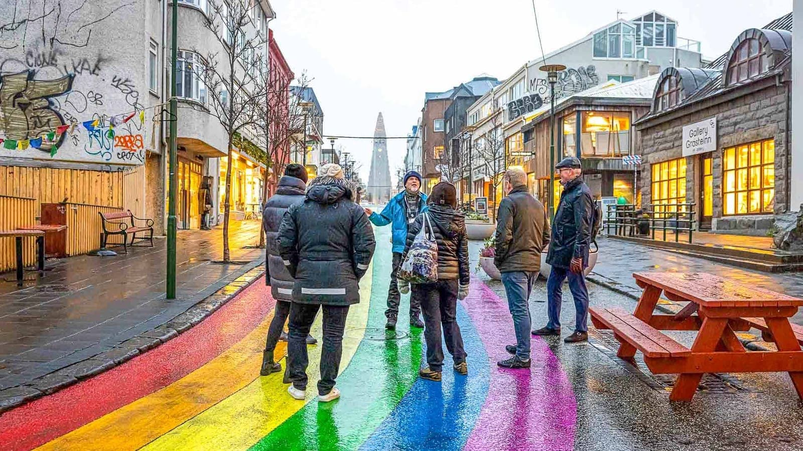 Travelers walking on the rainbow street in central Reykjavik on a wet day