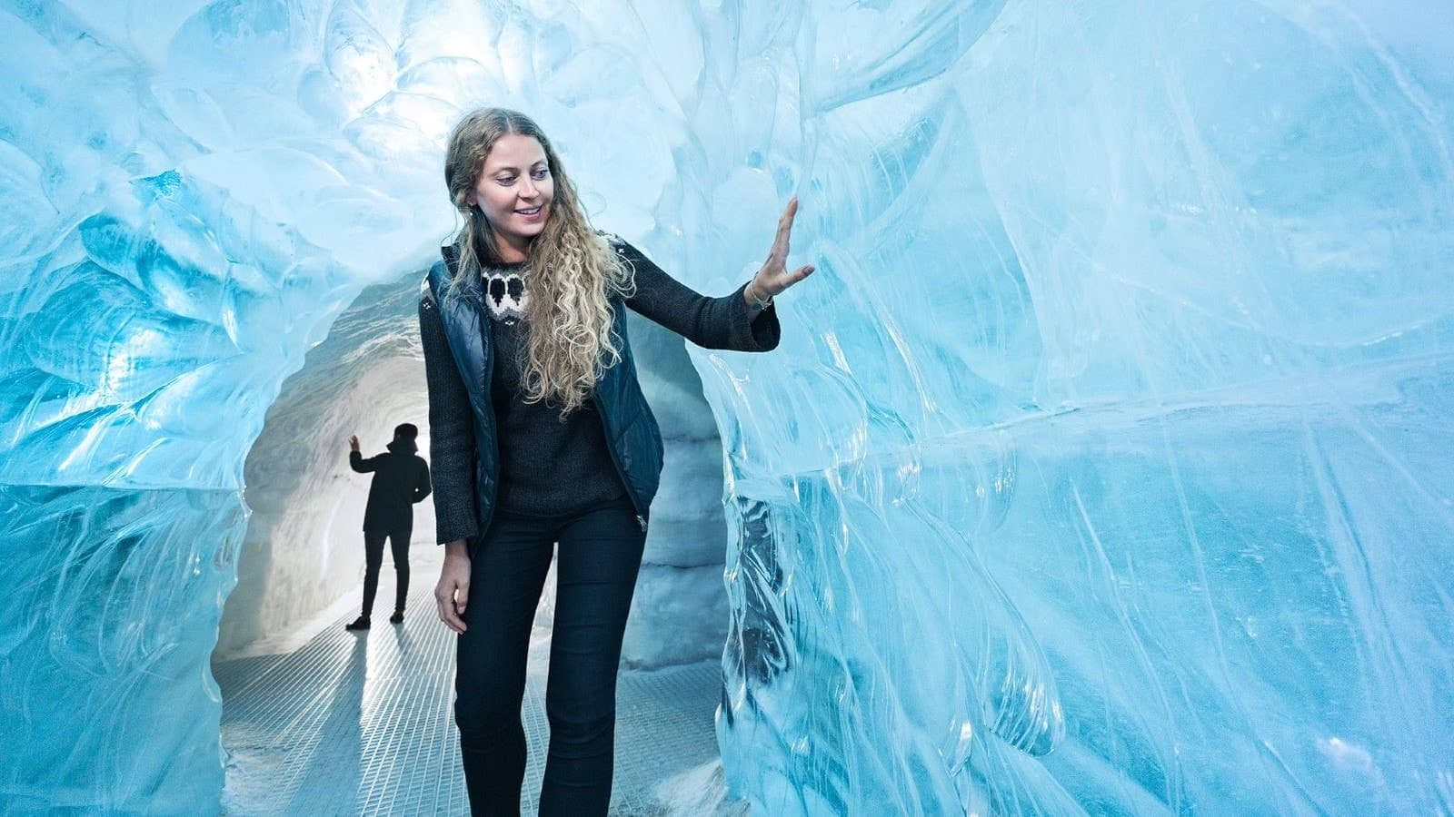 Visitor walking through the indoor ice cave exhibit at Perlan in Reykjavik