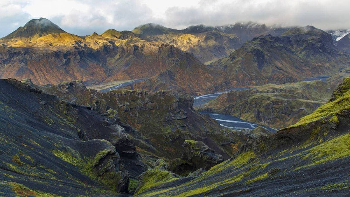 Dark lava ridges and mossy slopes in the Kristnitökuhraun lava field near Hellisheiði.