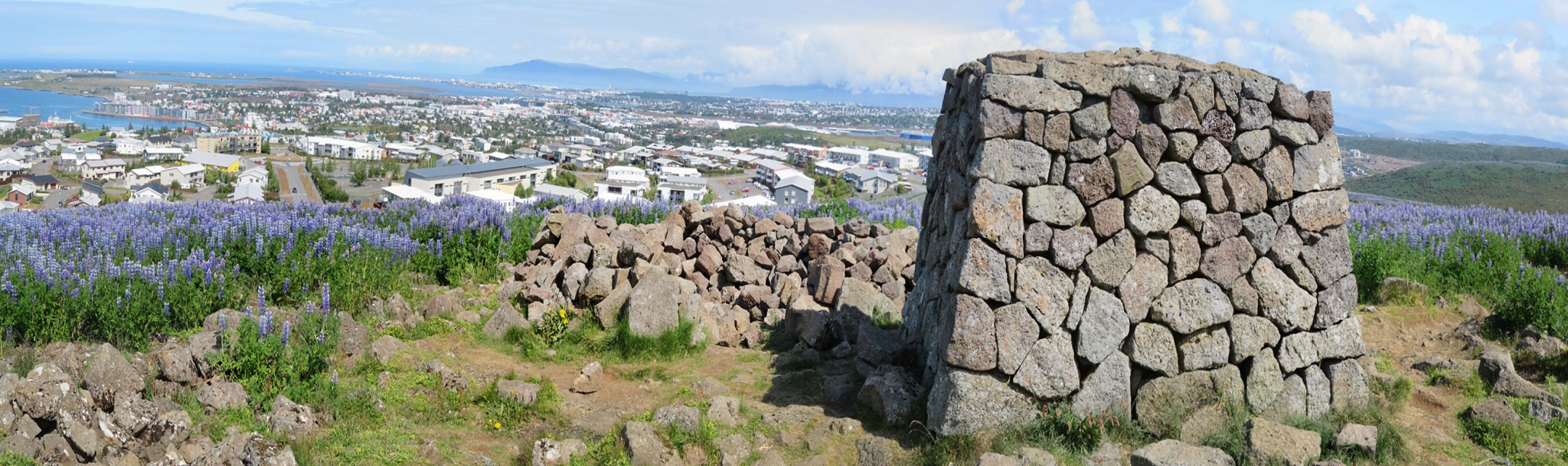 Wide Ástjörn and Ásfjall landscape near Hafnarfjörður with low hills and lake-area greenery.