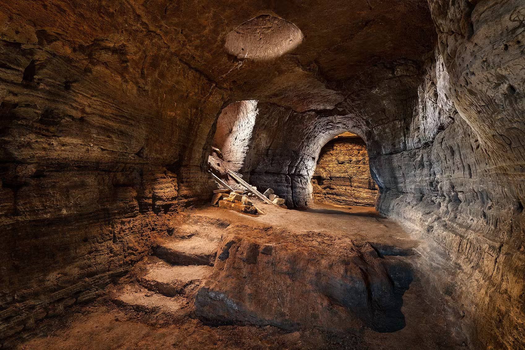 Lit sandstone chamber inside the Caves of Hella at Ægissíða near Hella