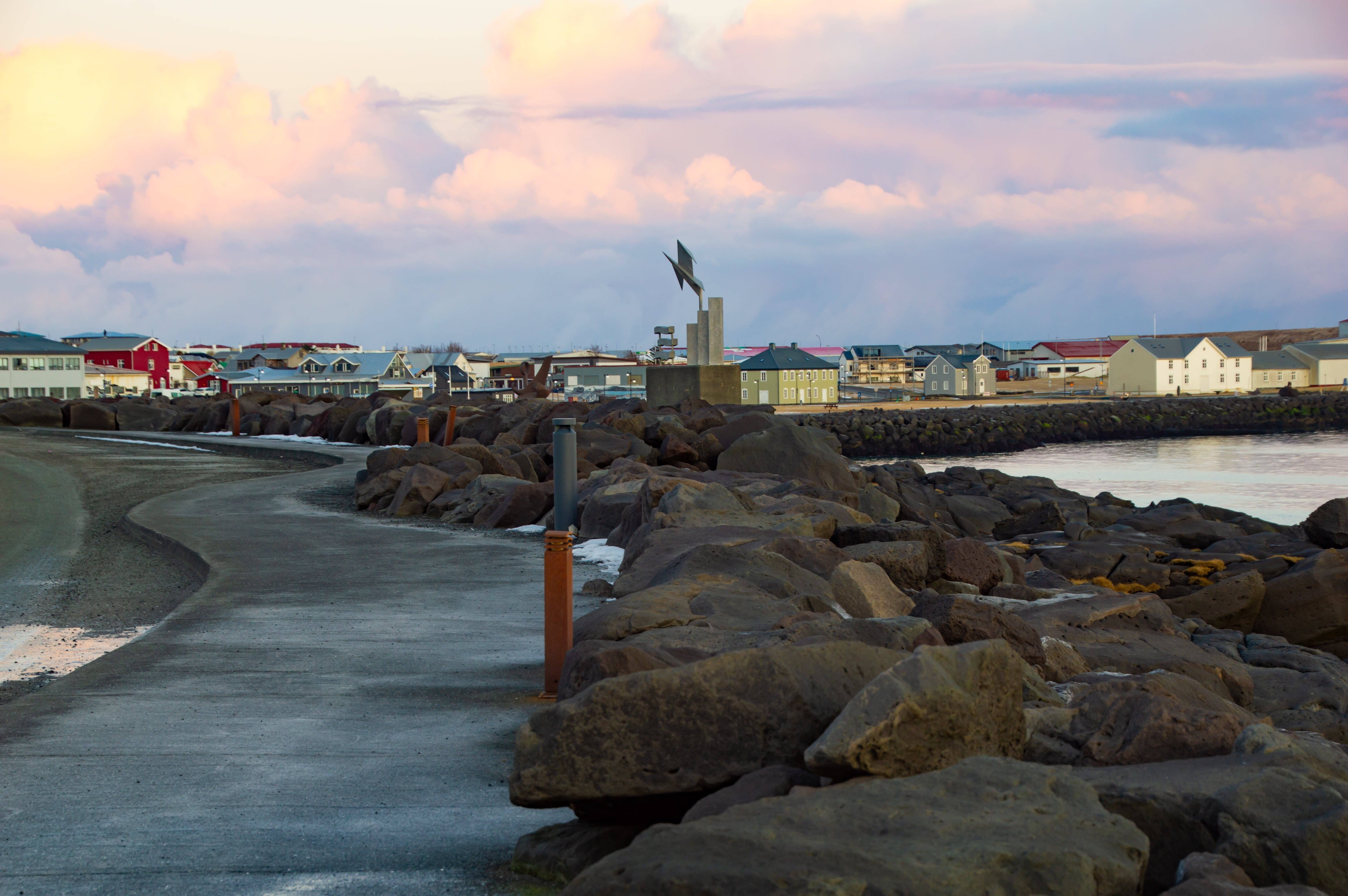 Coastal path and volcanic rock shoreline near Keflavík harbor.