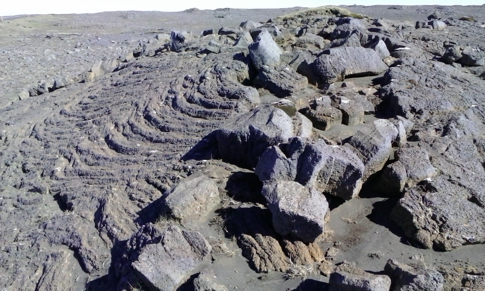 Layered volcanic rock near Hafnaberg with low Reykjanes terrain beyond.