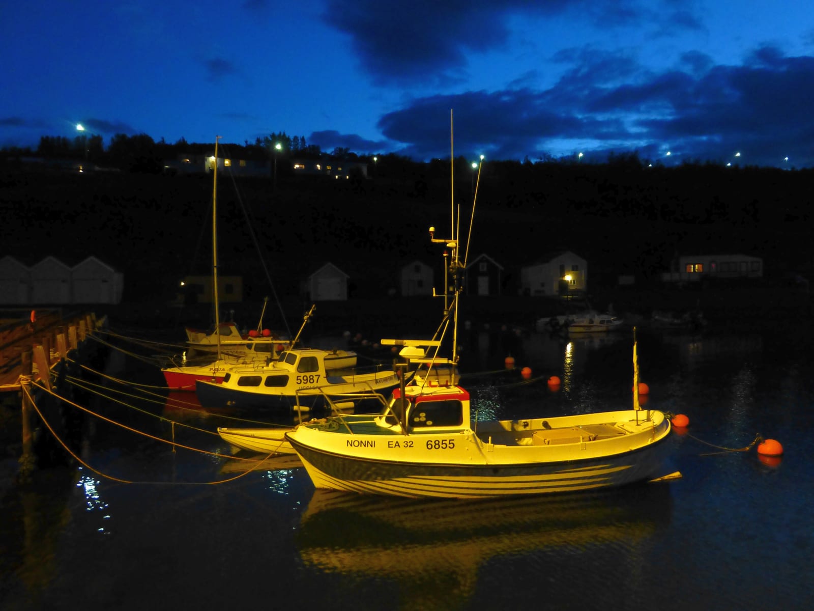 Small boats in Hjalteyri harbor with the old herring factory behind them