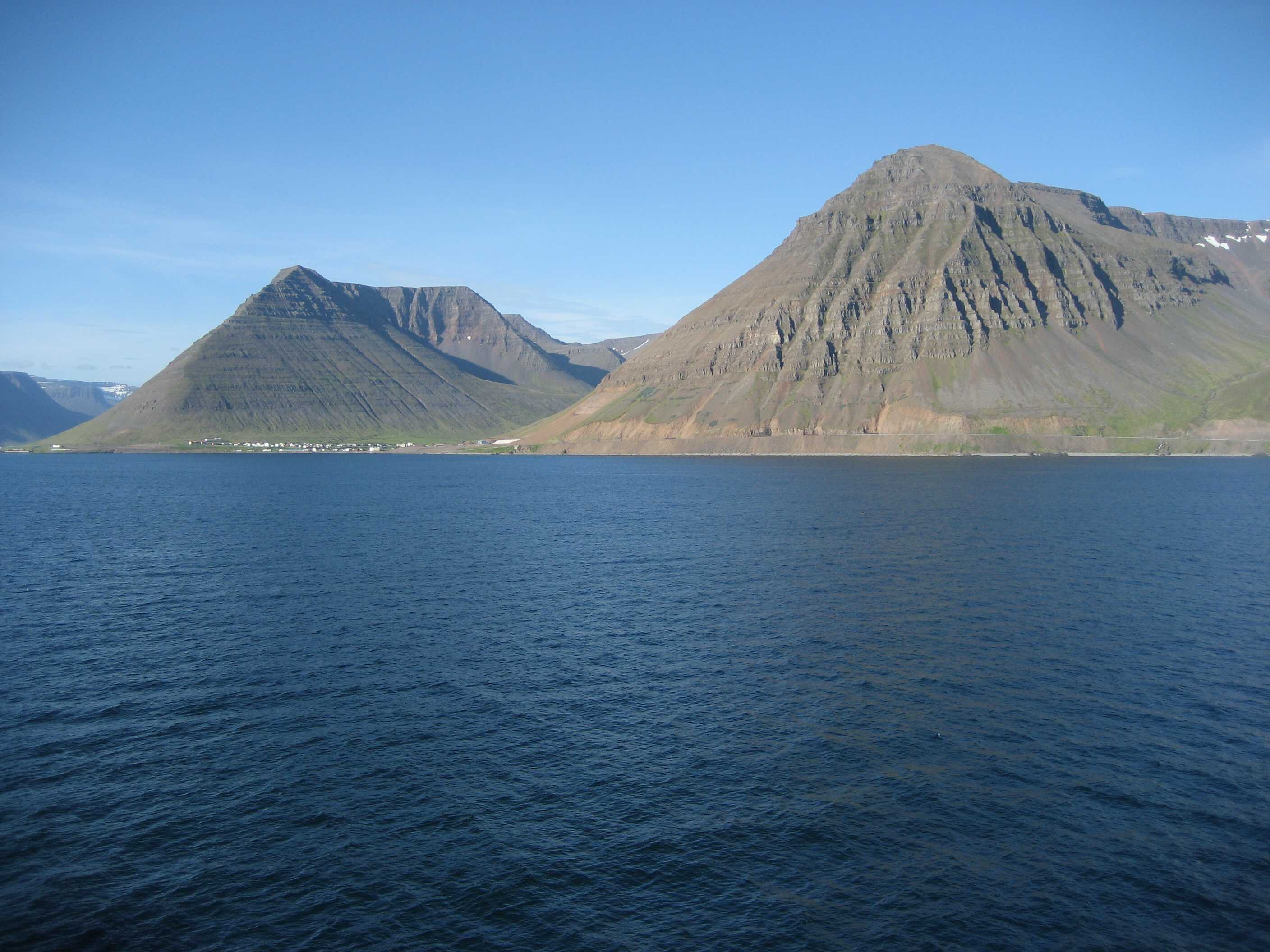 Hnífsdalur seen across the water beneath the cliffs near Óshlíð in the Westfjords.