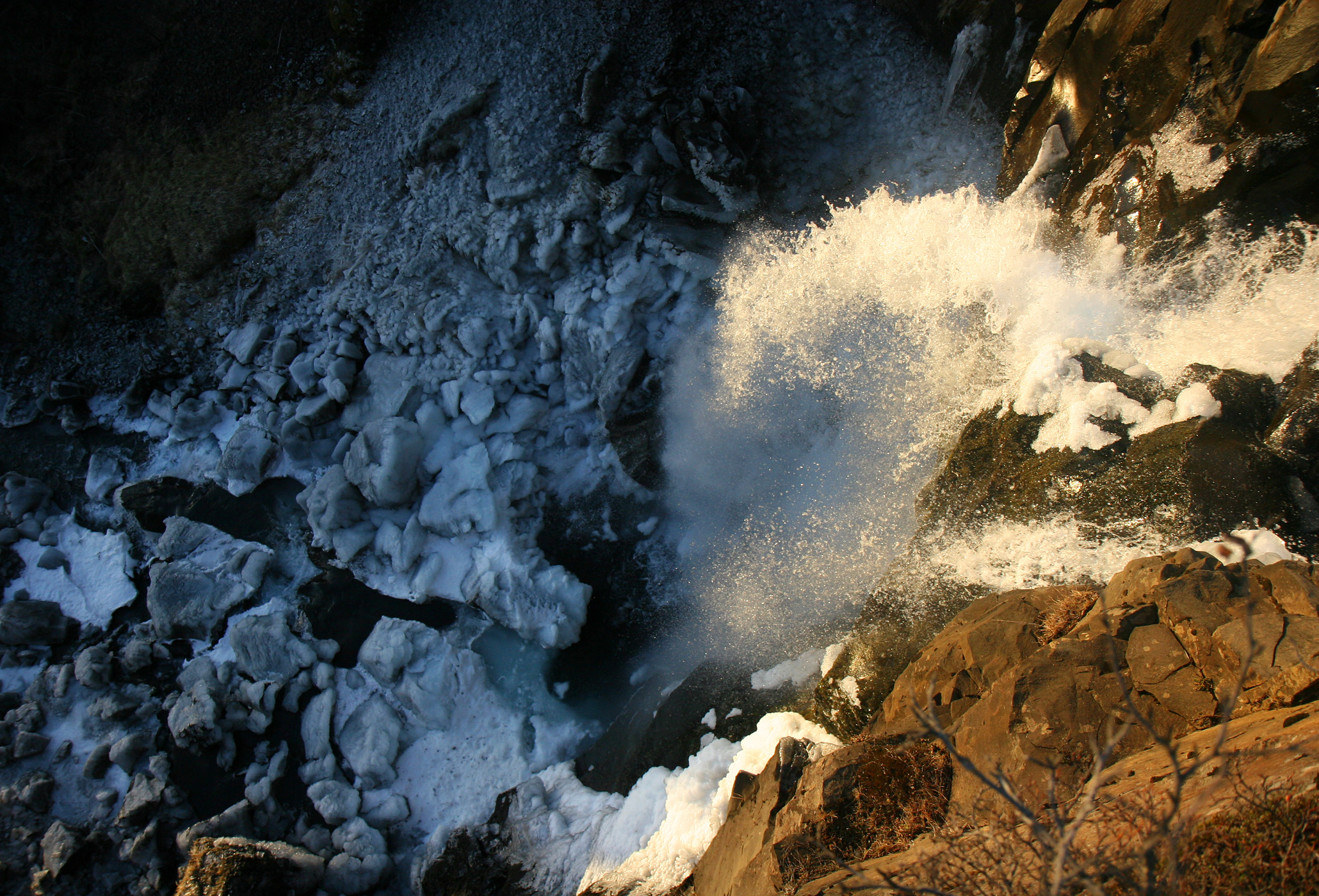 View over the edge of Hundafoss with water dropping into the Skaftafell gorge.