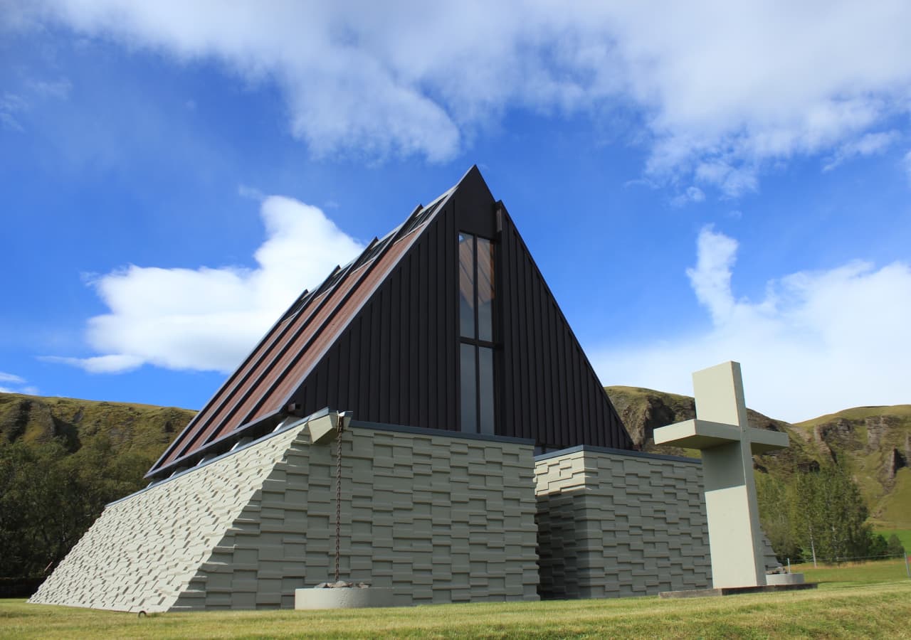 Reverend Jón Steingrímsson chapel in Kirkjubæjarklaustur with the village cliffs behind it.