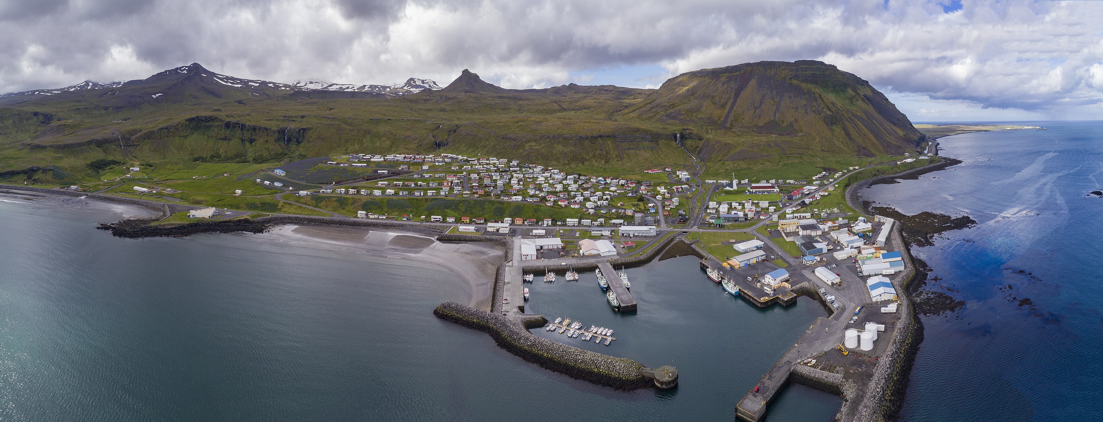 Aerial panorama of Ólafsvík, its harbor, church, coastline, and surrounding mountains