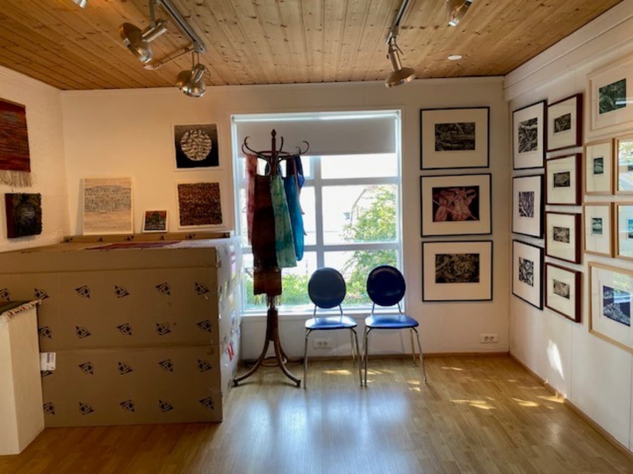 Interior of Gallery Snærós in Stöðvarfjörður with framed graphic works and a bright studio-like room.