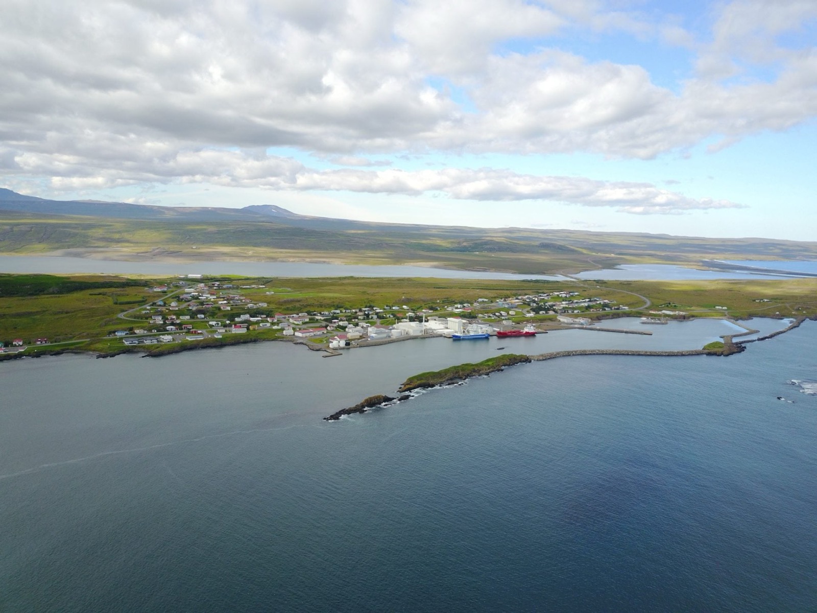 Aerial view of Vopnafjörður town on Kolbeinstangi with the broad fjord opening around it.