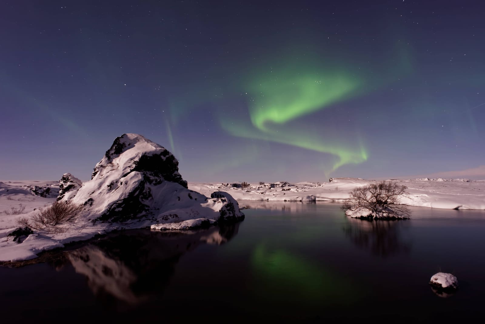 Northern lights reflected over snowy Lake Myvatn in North Iceland.