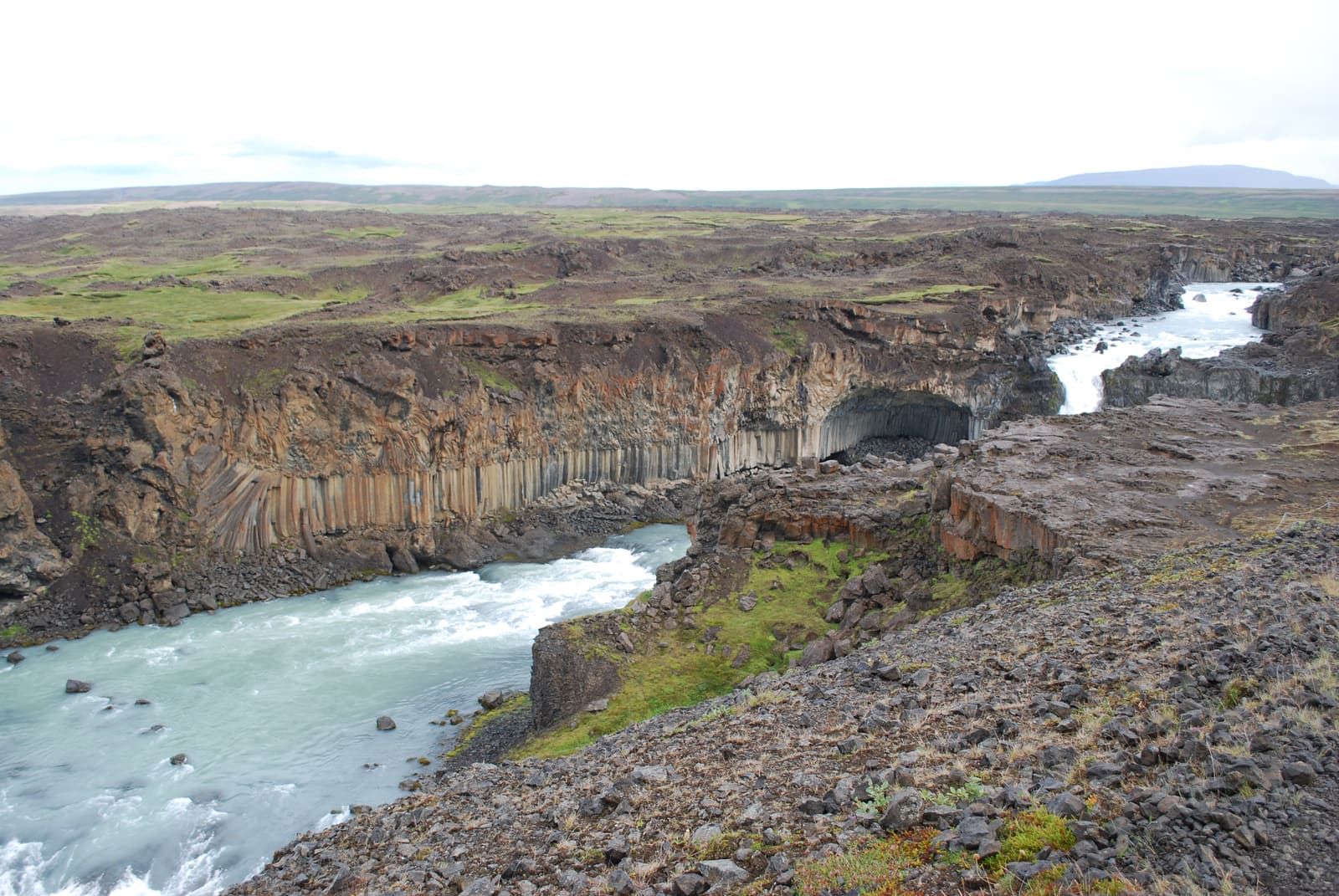 A wide view of the Skjálfandafljót river cutting past basalt columns at Aldeyjarfoss.