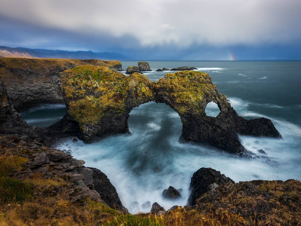 Gatklettur sea arch at Arnarstapi with Atlantic surf below the lava cliffs.