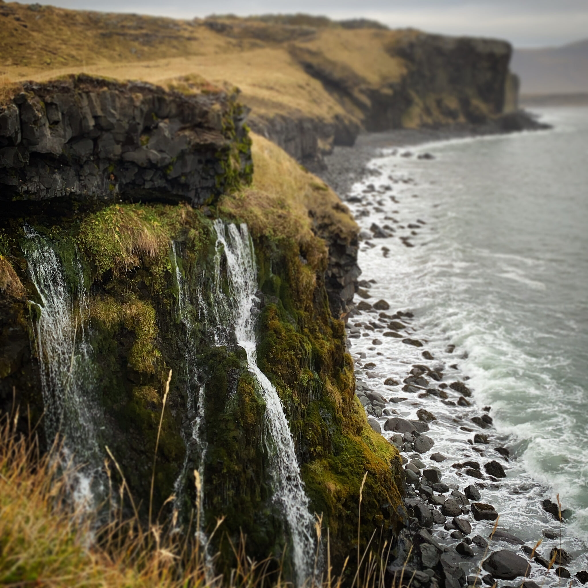 Sölvahamar coastal cliffs near Arnarstapi with water dropping toward the rocky shoreline.