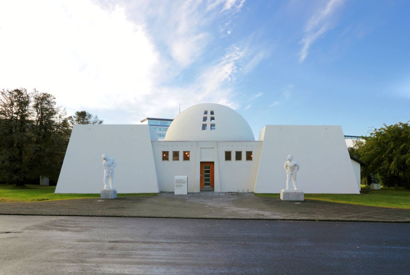 Front of Ásmundarsafn with the domed roof and two white sculptures beside the entrance.