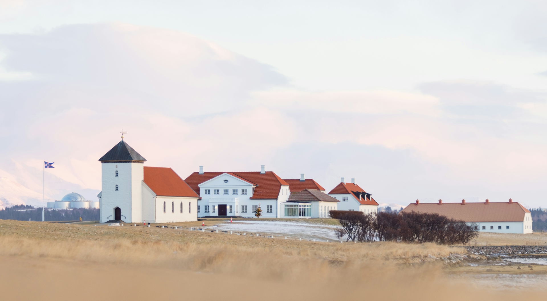 Bessastaðir buildings on Álftanes with pale winter light and mountains behind.