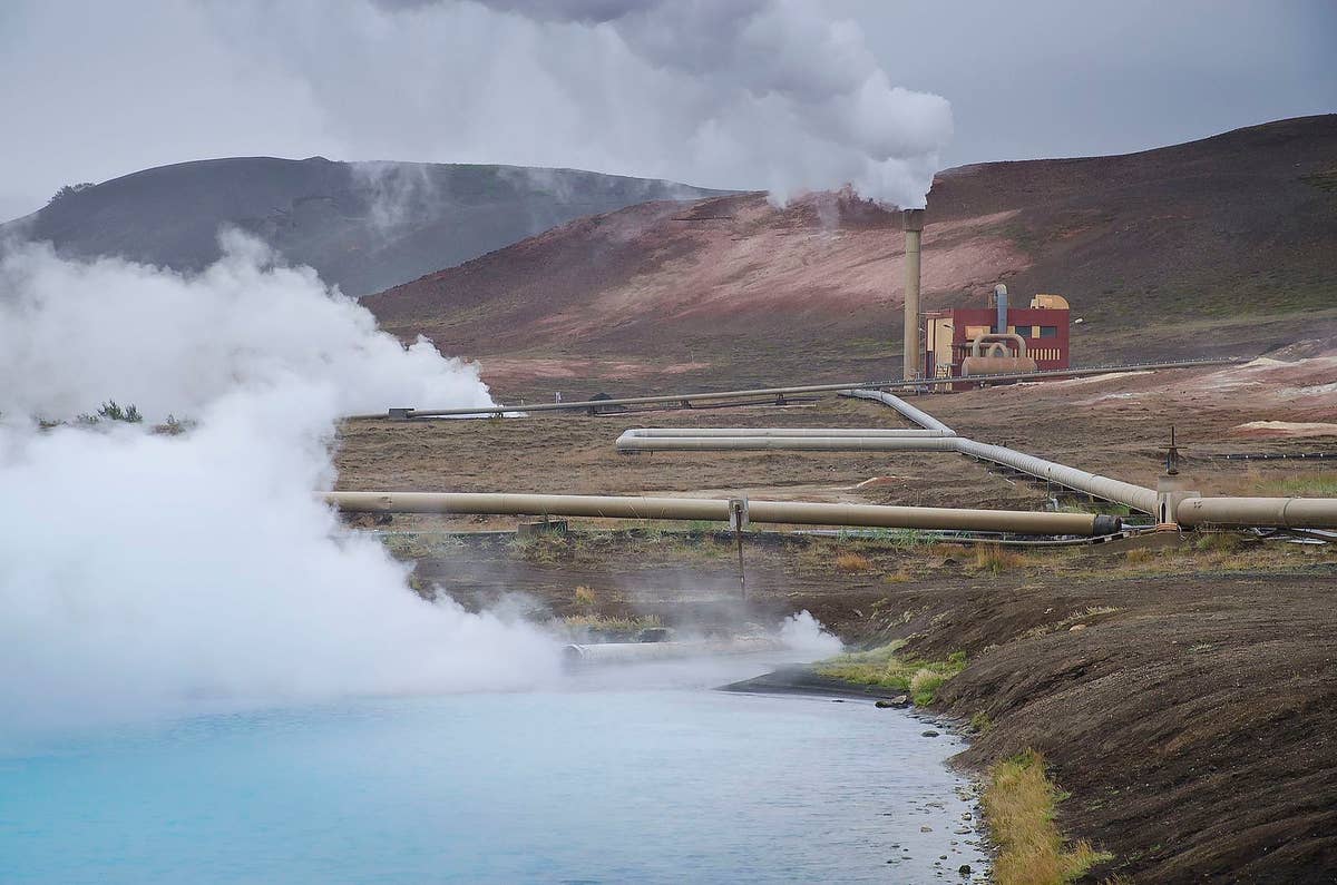 Blue geothermal water, steam, pipes, and the Bjarnarflag power station building in the Mývatn area.