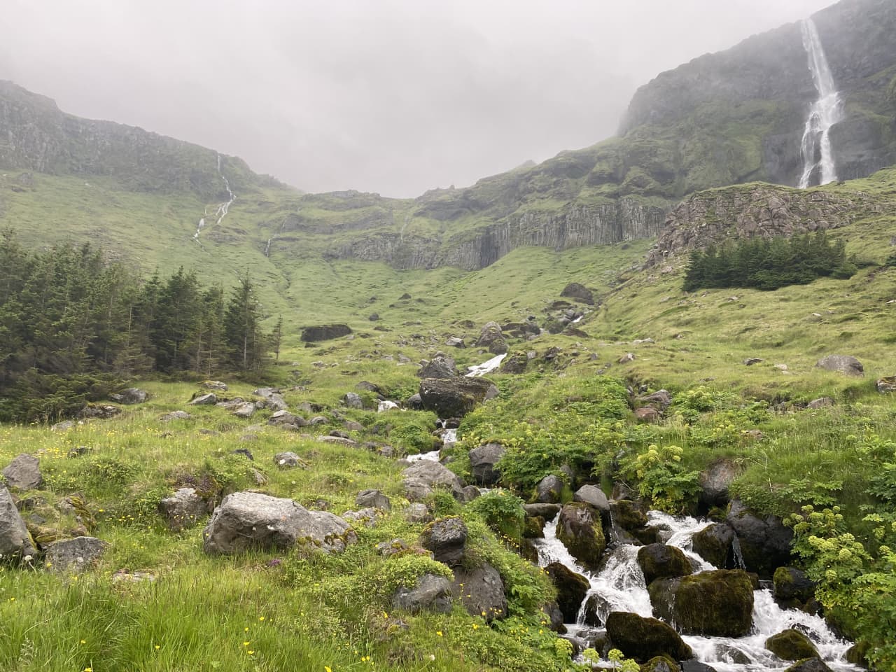 Bjarnarfoss Waterfall above the grassy valley and rocky stream above Búðir on Snæfellsnes.