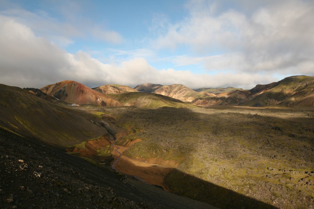Clouds and shifting light over the Landmannalaugar lava field and colored mountains below Bláhnjúkur.
