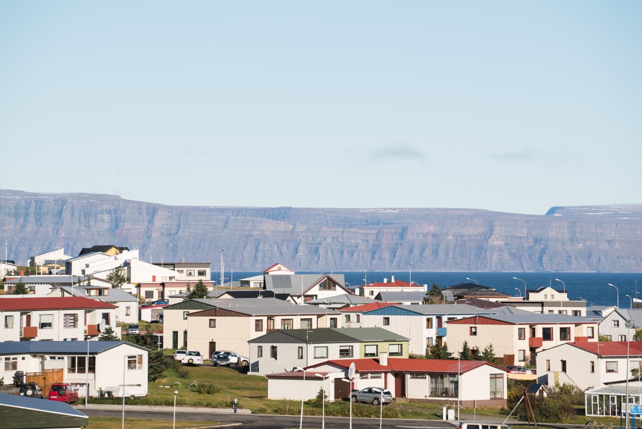 Bolungarvík houses beside the fjord with steep Westfjords cliffs across the water.