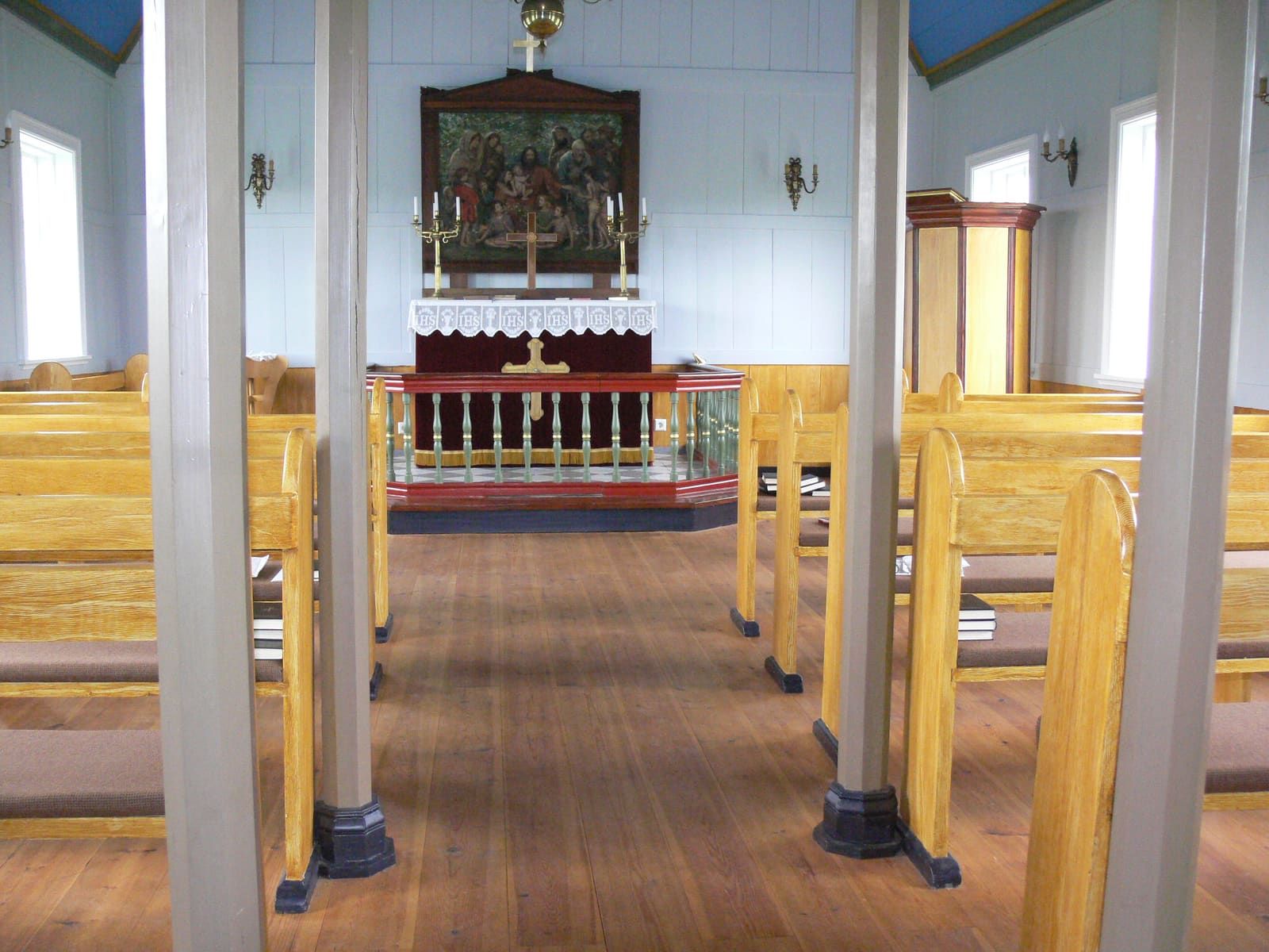 Interior of Borg á Mýrum church with wooden pews and the altar at the far wall