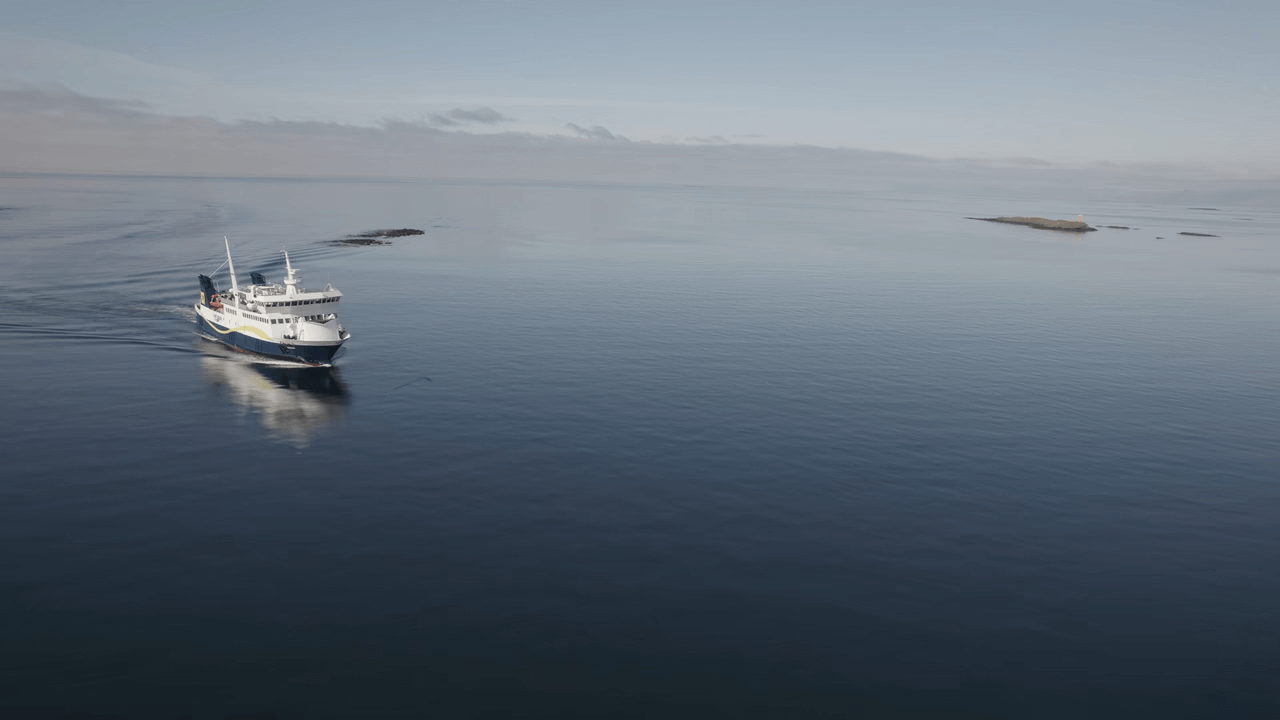 Baldur ferry crossing calm water in Breiðafjörður with small islands nearby.