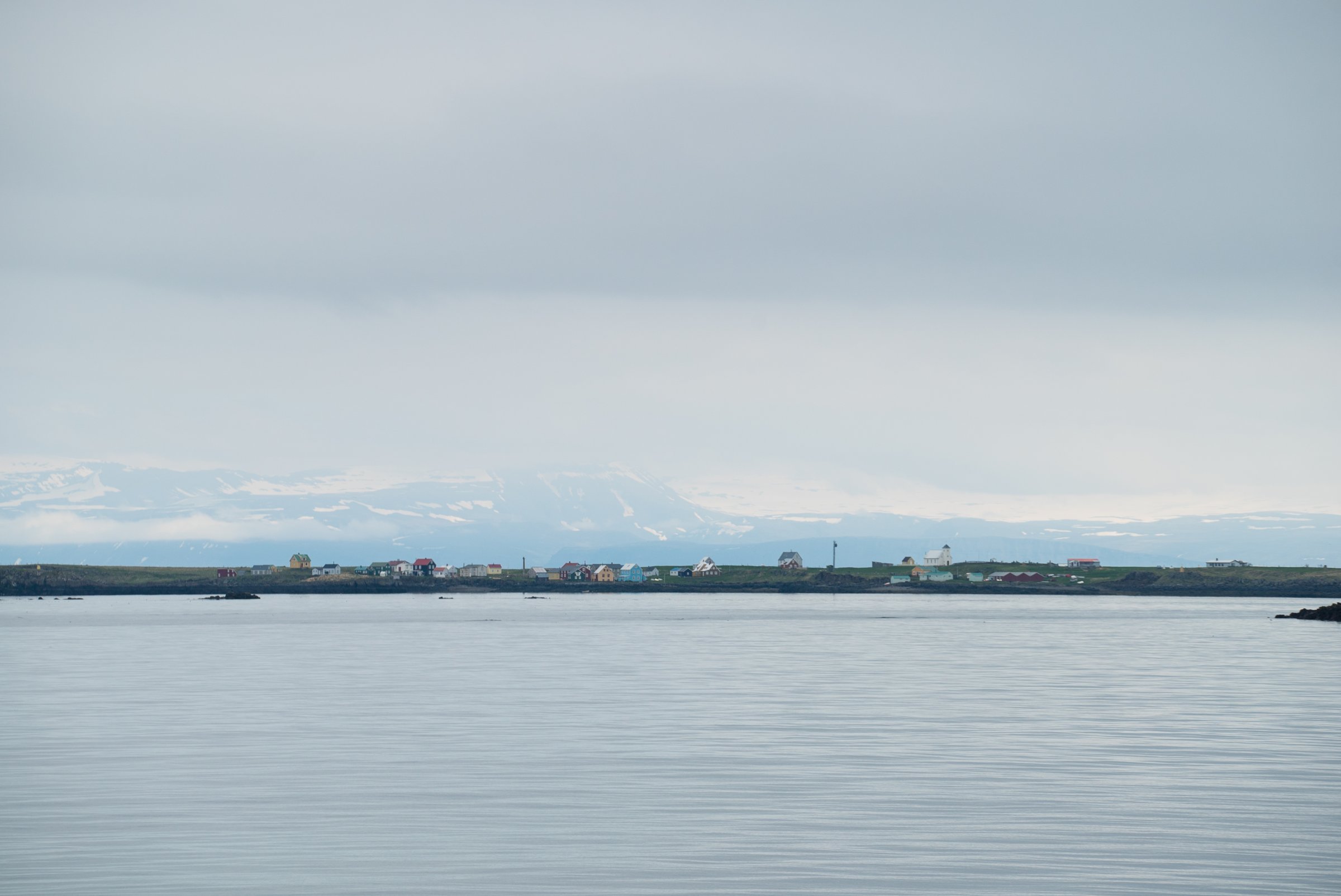 Flatey village and the water of Breiðafjörður below pale mountains.