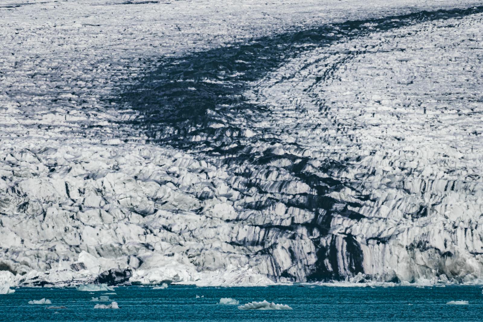 Dark medial moraine bands running through cracked white ice on Breiðamerkurjökull.