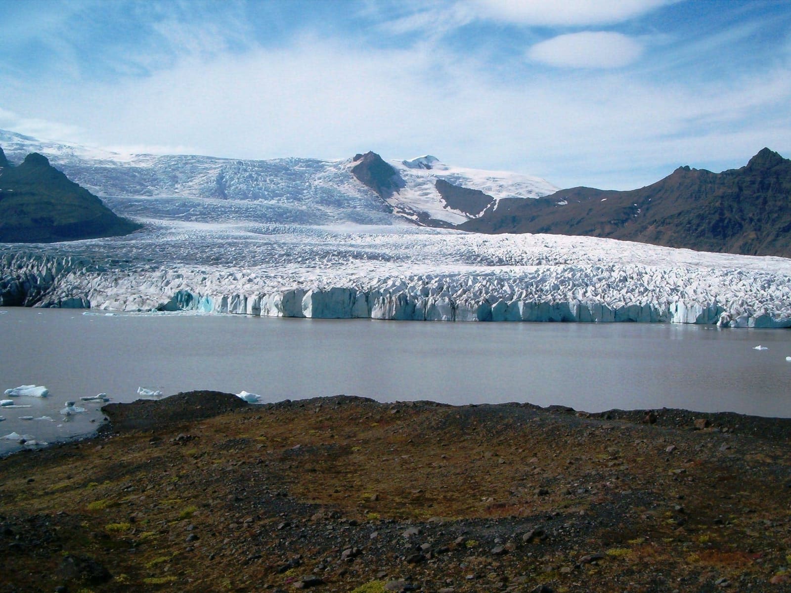 Breiðárlón Glacier Lagoon below Vatnajökull ice with water, moraine, and mountains in view.