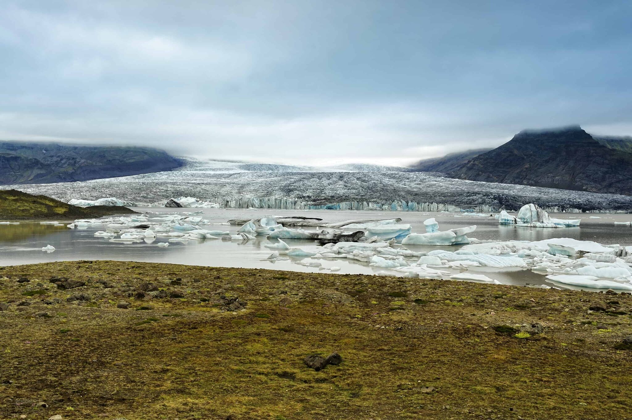 Large ice pieces and glacier water at Breiðárlón with the Vatnajökull outlet glacier behind.