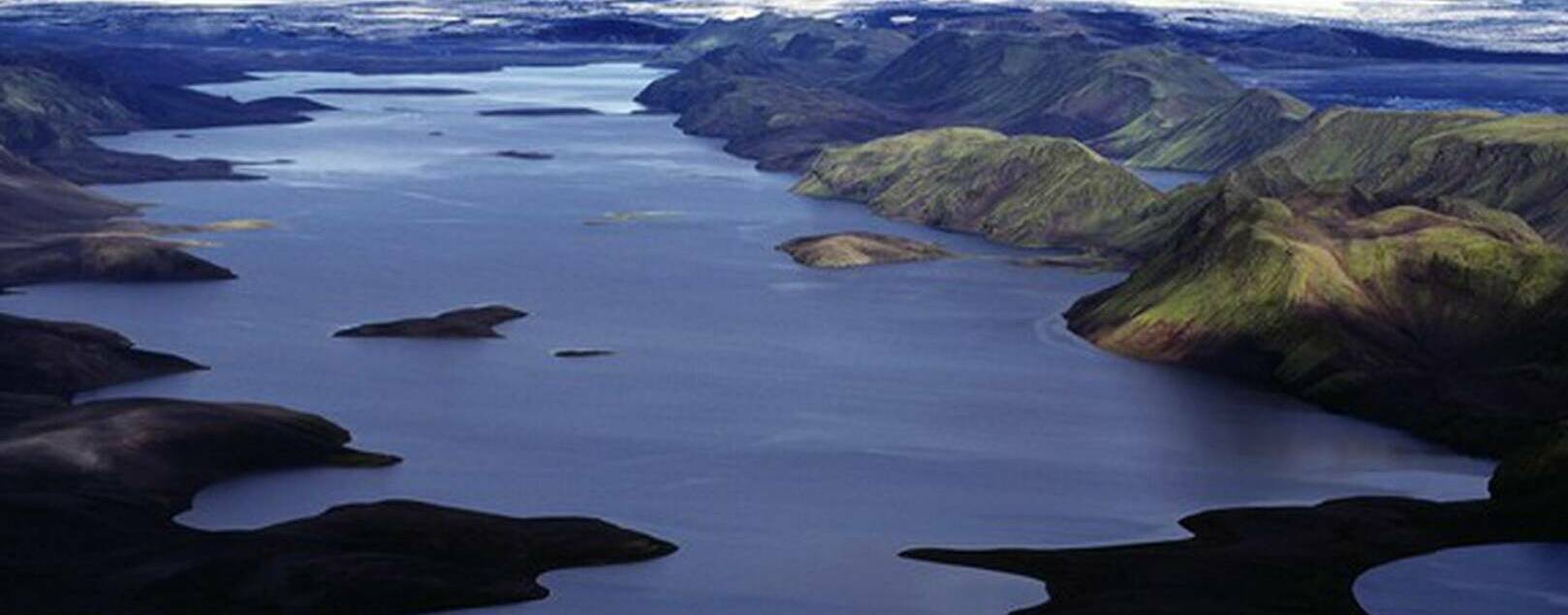 Wide highland panorama of Langisjór with dark ridges and distant glacier ice near Breiðbakur.