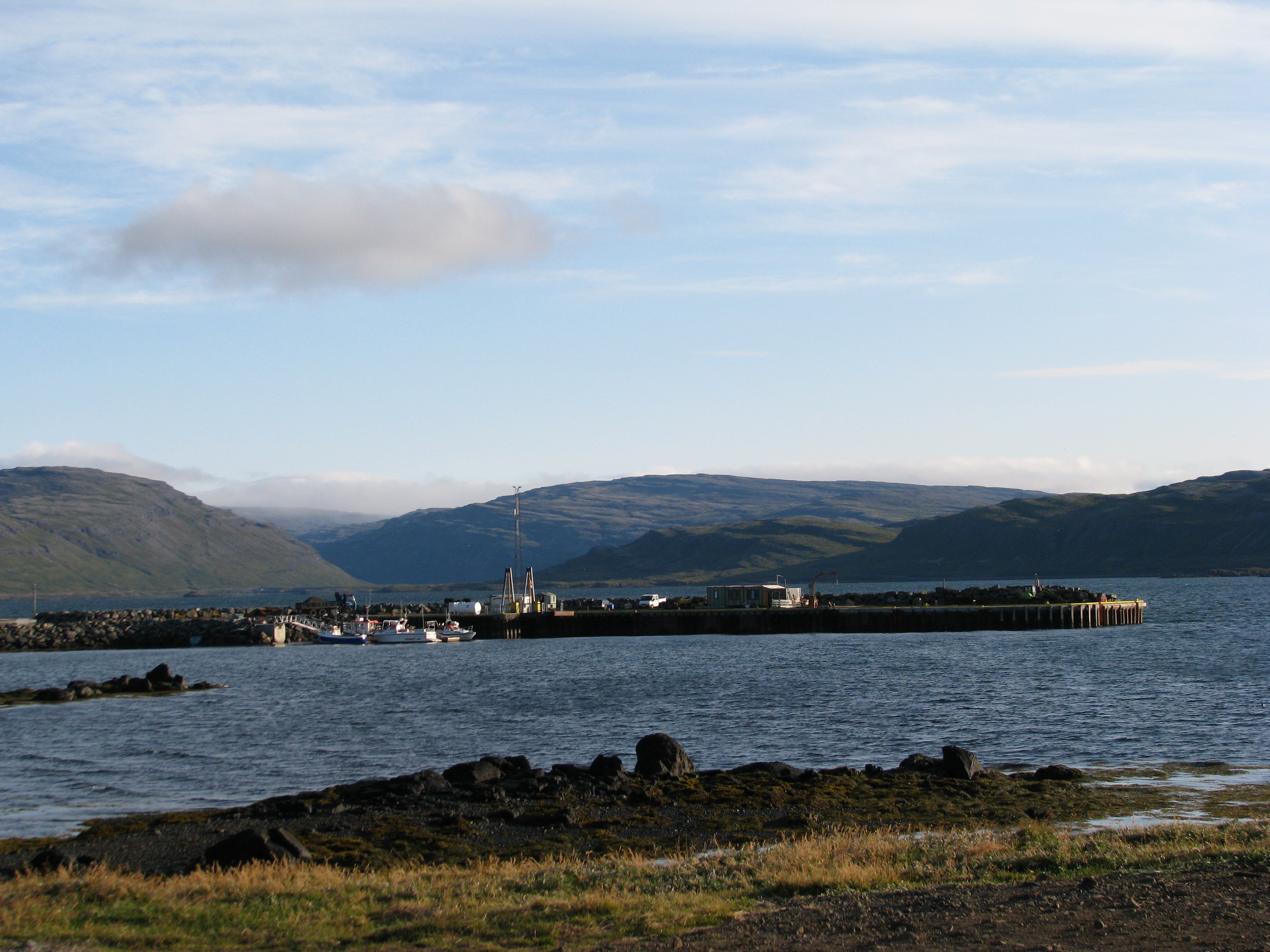 Brjánslækur harbor pier and landing area with Westfjords slopes across the bay.