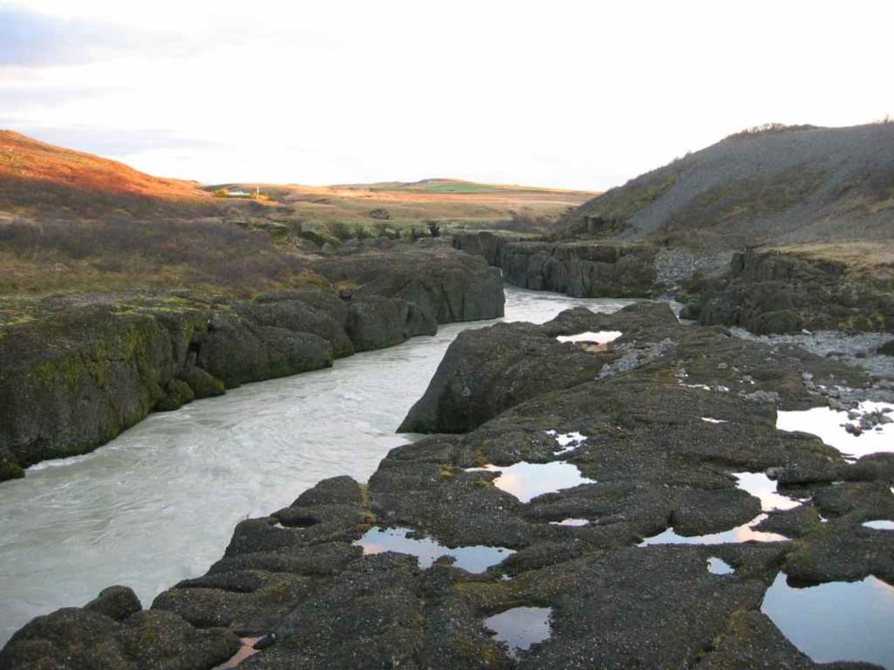 Brúarhlöð Canyon with pale Hvítá river water running between dark carved rock walls.