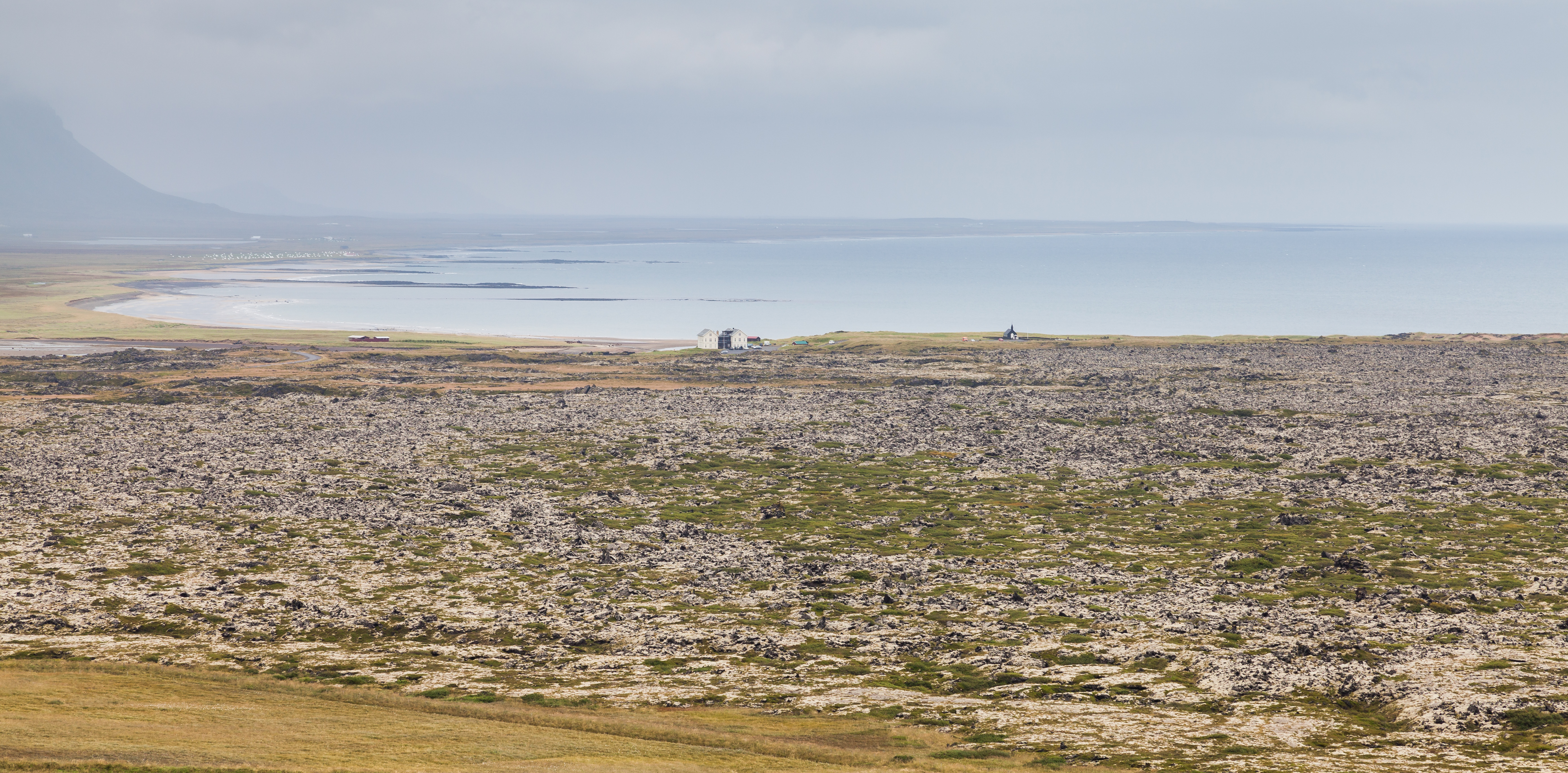 Búðahraun lava field, pale sand, mossy lava, Búðakirkja, and Snæfellsnes mountains near Búðir.