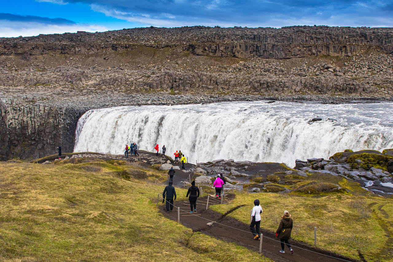 Visitors walking on the roped path toward Dettifoss waterfall in North Iceland.
